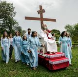 Ein "Jesus" in Brasilien lässt sich auf einem rollenden Podest durch die Gegend geleiten. Immer mit dabei: das Kreuz.