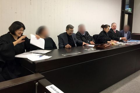 Auf der Anklagebank im Landgericht Stuttgart sitzen die angeklagten Eltern und der Onkel zwischen Anwälten und Dolmetscher