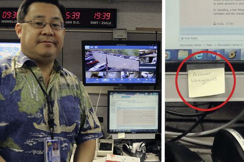 Ein asiatisch aussehender Mann mit Brille und Hawaii-Hemd steht vor einem Schreibtisch mit vier Monitoren