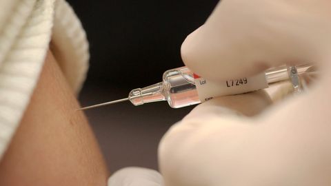 Eine Frau lässt sich gegen Grippe impfen.