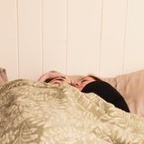 Polyamorie: Luke und Megan kuscheln im Bett.