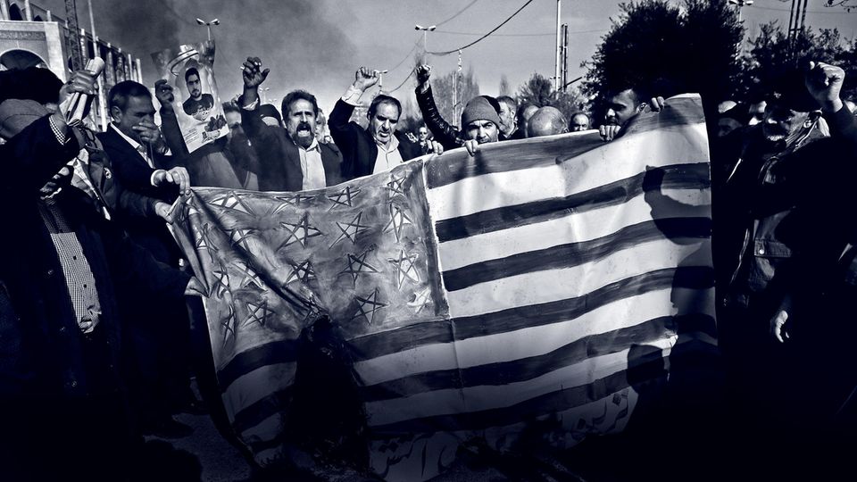 Unruhe in der Islamischen Republik: Regierungstreue Demonstranten verbrennen eine US-Flagge in den Straßen Teherans Regierungstreue Demonstranten verbrennen eine US-Flagge in den Straßen Teherans