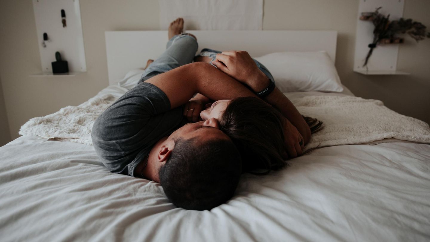 Mann und Frau liegen eng umschlungen auf dem Bett