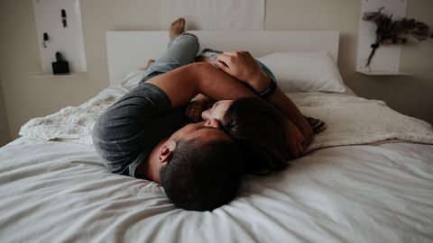 Mann und Frau liegen eng umschlungen auf dem Bett