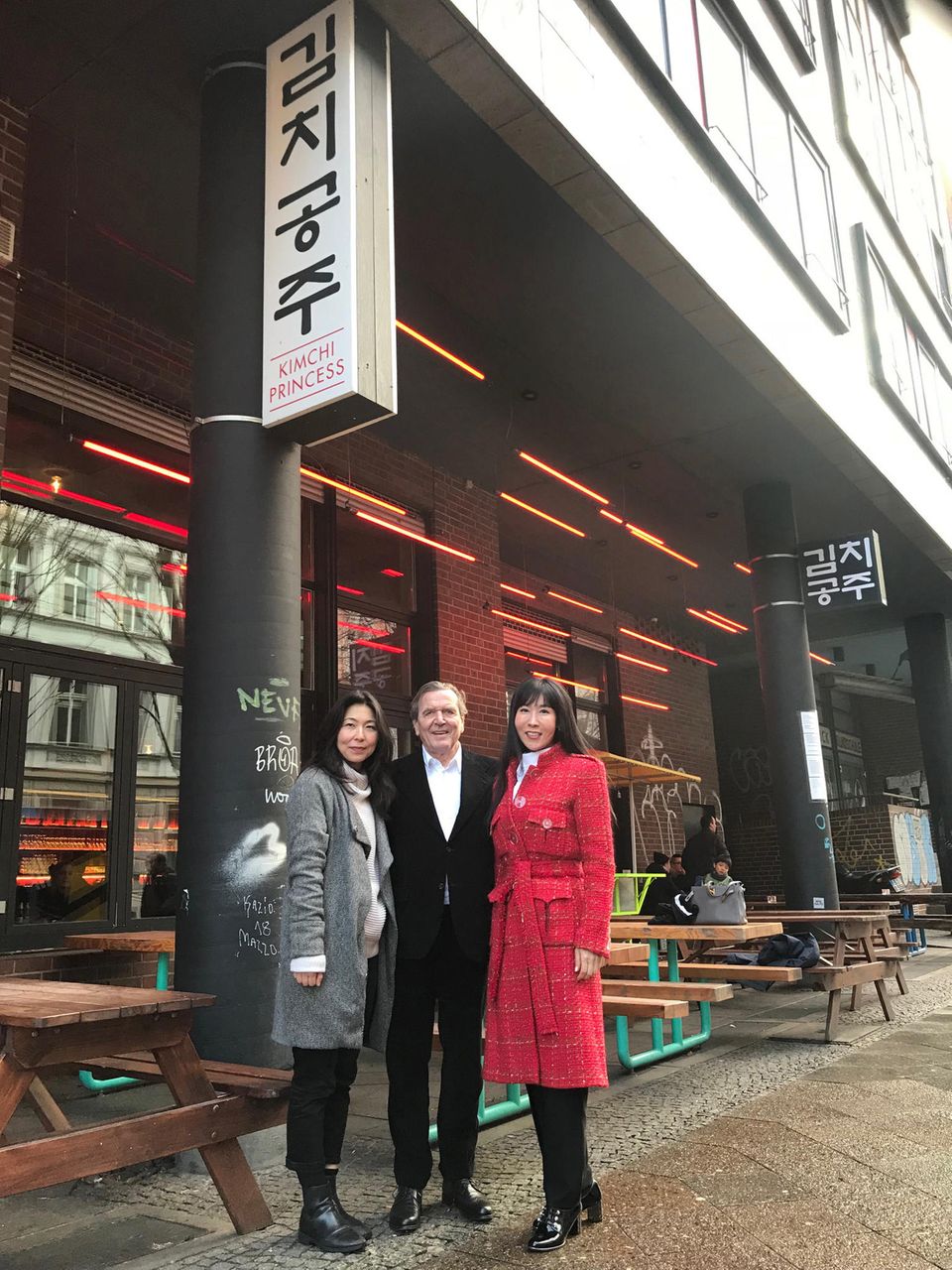 Gerhard Schröder und Soyeon Kim posieren mit der Inhaberin des Restaurants "Kimchi Princess"