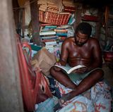 Matolias sitzt im Inneren seiner Sandburg. Um ihn herum sind ganz viele Bücher.