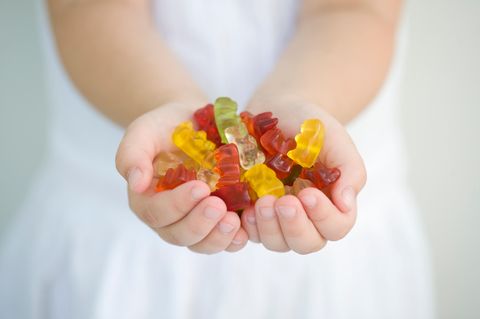 Mädchen hält Gummibärchen in den Händen
