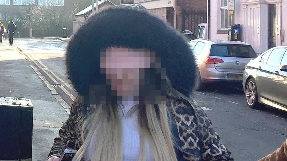 In einer Jacke mit Tierprint wird die Frau zum Gericht geführt