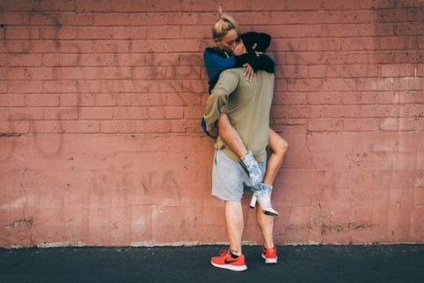 Eine Frau hängt klammernd an einem Mann. Beide küssen sich – haben sie vielleicht Freundschaft Plus?