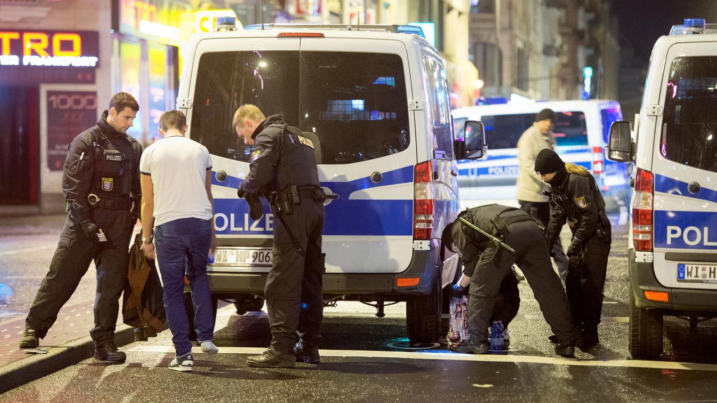 Polizisten kontrollieren einen Mann