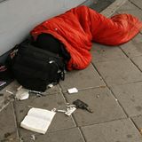 Ein heroinabhängiger Mann liegt auf dem Gehweg,