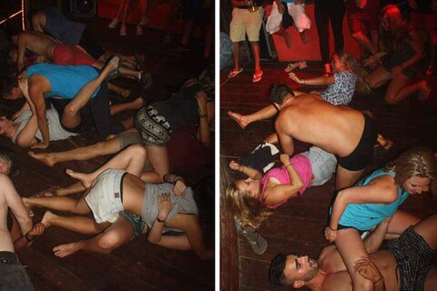 Ein dutzend jüngere Erwachsene tanzen auf dem Boden liegend miteinander auf einer Party in Kambodscha.
