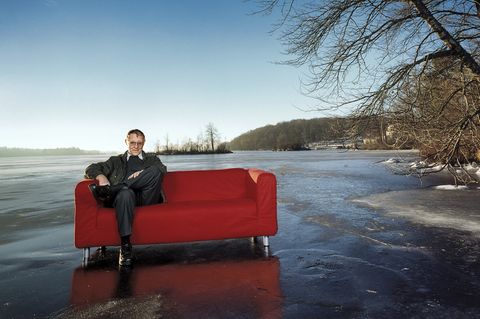 Ikea-Gründer Ingvar Kamprad sitzt auf einem zugefrorenen See auf einem "Klippan"-Sofa