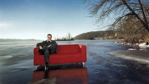 Ikea-Gründer Ingvar Kamprad sitzt auf einem zugefrorenen See auf einem "Klippan"-Sofa