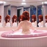 Eine nackte Frau sitzt in einer herzförmigen Badewanne in einer Honeymoon Suite