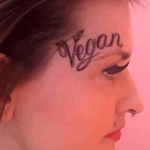 Ein Frauengesicht, auf dessen Stirn ein "Vegan" tätowiert ist
