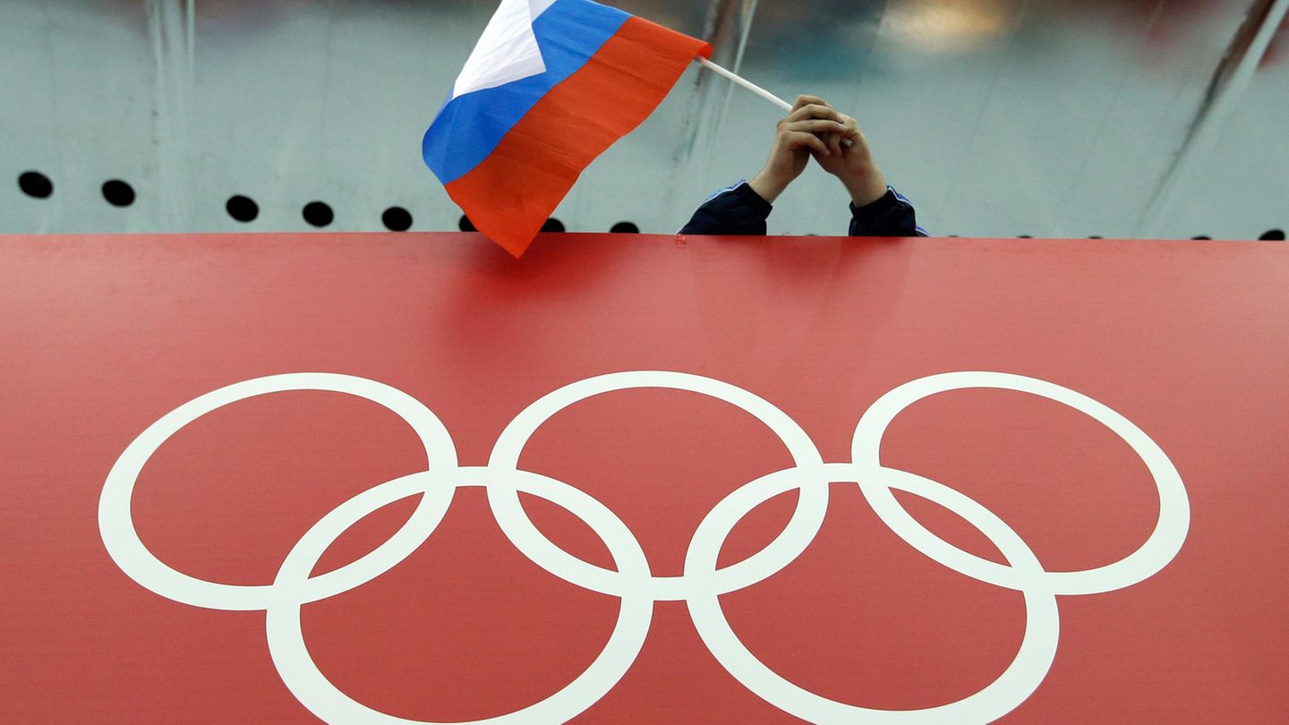 Fan schwenkt Russland-Flagge, darunter olympische Ringe. CAS hebt Sperren für Olympia für russische Sportler auf