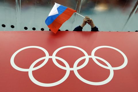Fan schwenkt Russland-Flagge, darunter olympische Ringe. CAS hebt Sperren für Olympia für russische Sportler auf