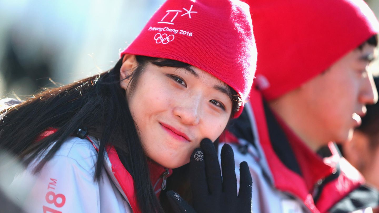 Freiwillige Helferin grüßt in die Kamera - Olympia-Dorf in Pyeongchang ist eröffnet