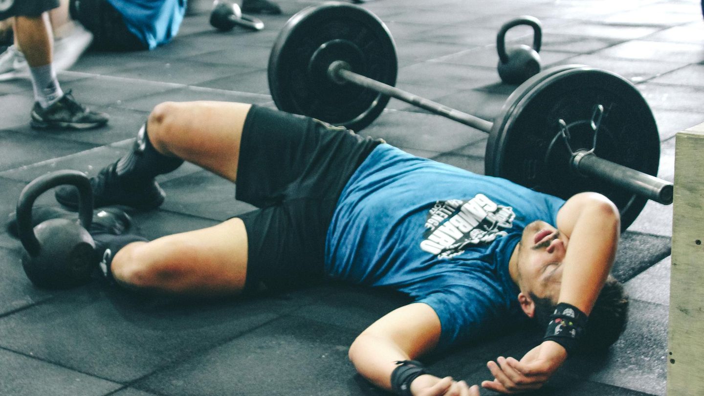 Ein Mann liegt im Fitnessstudio am Boden