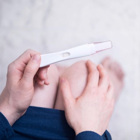 Frau mit Schwangerschaftstest in der Hand