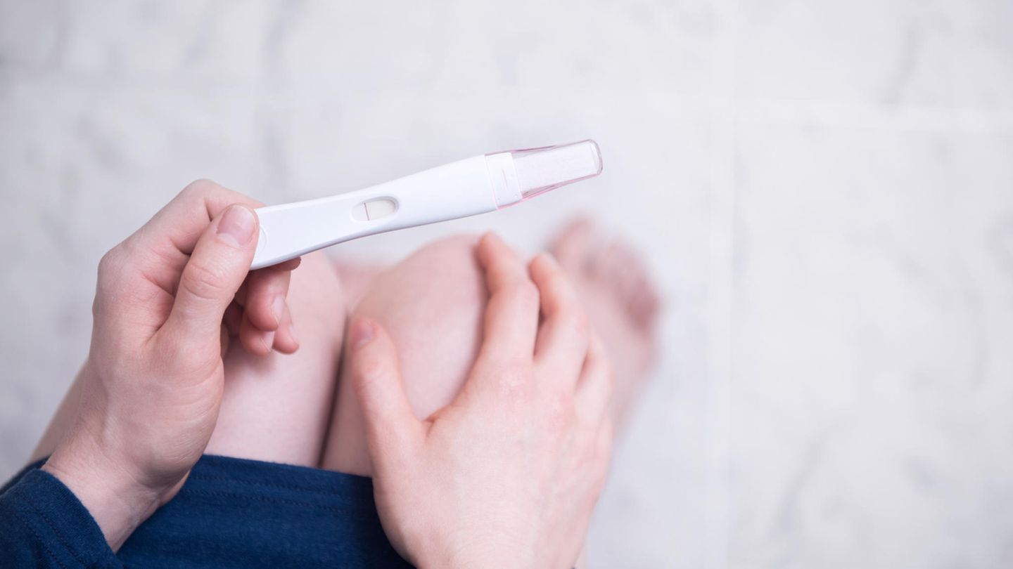 Frau mit Schwangerschaftstest in der Hand