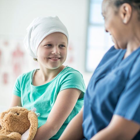Schwerkrankes Kind mit Kuscheltier und Krankenschwester