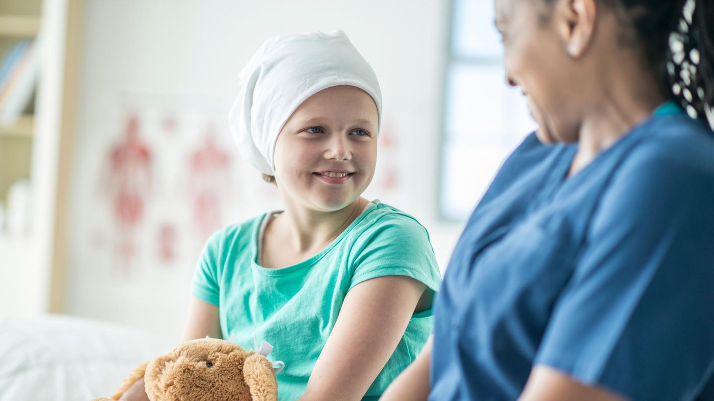 Schwerkrankes Kind mit Kuscheltier und Krankenschwester