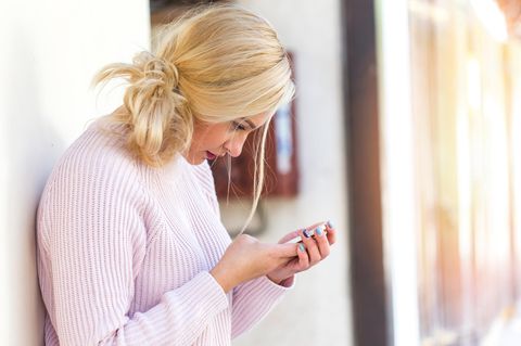 Junge Frau mit Smartphone in der Hand
