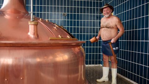 Bierbrauer Jürgen Hopf aus Oberfranken steht nur emit Schürze, Hut und Gummistiefel bekleidet in der Lang-Bräu-Brauerei.