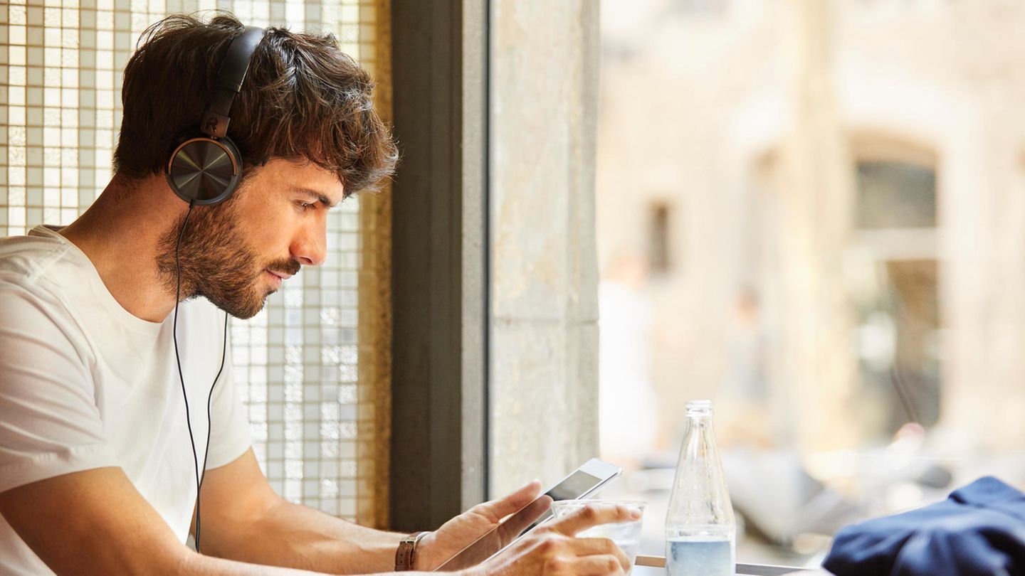T-Shirt: Junger mann surft auf Smartphone