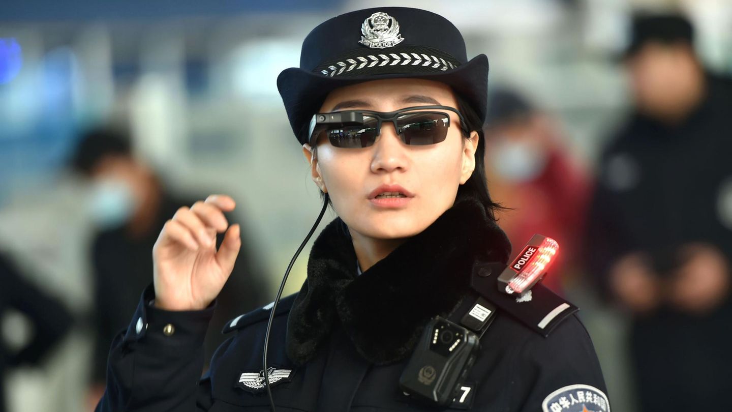 Eine Polizistin an einem Bahnhof in China mit den neuen Sonnenbrillen mit integrierter Software für Gesichtserkennung