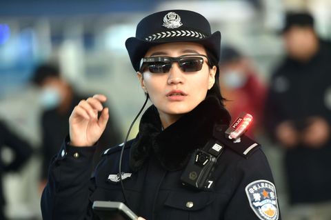 Eine Polizistin an einem Bahnhof in China mit den neuen Sonnenbrillen mit integrierter Software für Gesichtserkennung