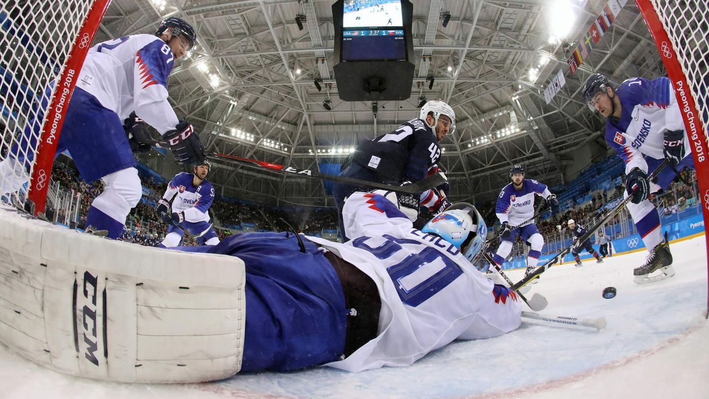 Voll geblockt: Der Torwart der slowakischen Eishockey-Mannschaft wehrt mit vollem Einsatz den Torschuss von US-Boy Chad Kolarik ab. Am Ende gewannen die Amerikaner das Spiel mit 2:1