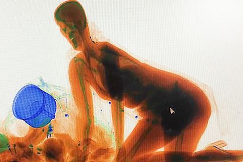 Paranoia bei der Sicherheitskontrolle: Frau klettert auf High Heels in Gepäck-Scanner