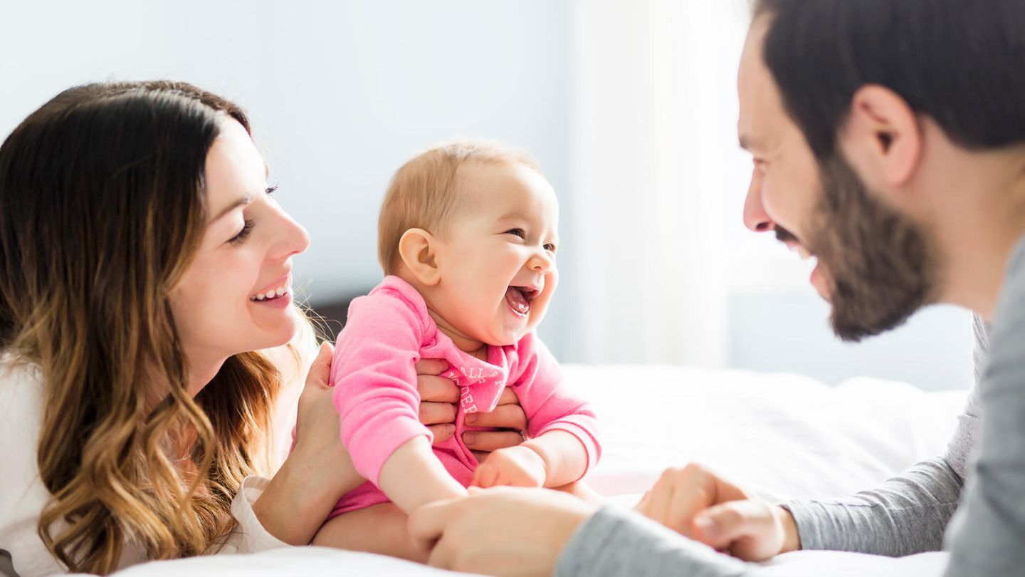 Ein Baby lacht seinen Vater an