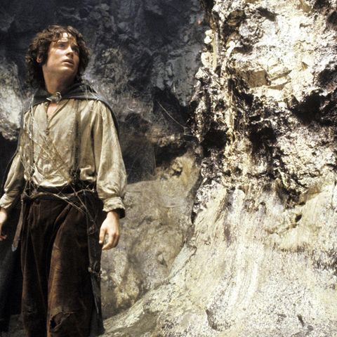 Frodo – der Hobbit aus "Der Herr der Ringe" steht vor einer Felswand