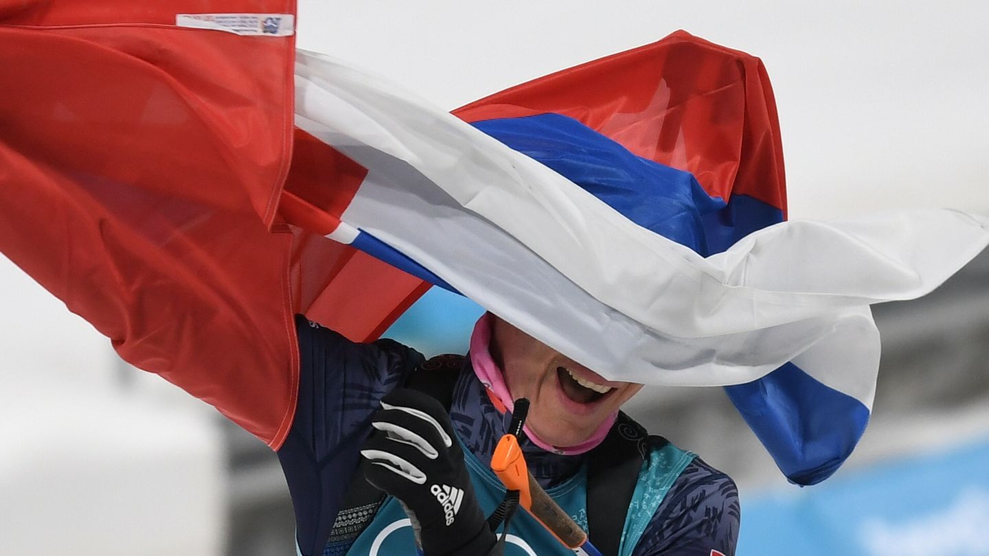 Kein Durchblick: Anastasiya Kuzmina aus der Slowakei bejubelt ihre Goldmedaille im Biathlon. Die Nationalflagge nimmt ihr dabei zwar die Sicht, aber die Schnellste beim Massenstart der Damen über 12,5 Kilometer lässt sich auch davon nicht aufhalten.