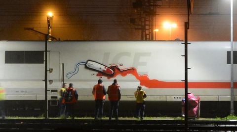 Personen stehen vor einem von Sprayer "RAZOR" besprühten ICE