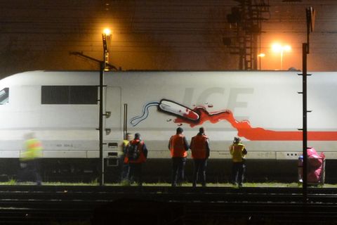 Personen stehen vor einem von Sprayer "RAZOR" besprühten ICE