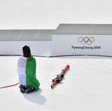 Im stiller Dankbarkeit: Die italienische Skirennläuferin Sofia Goggia kniet nach der Flowerzeremonie vor dem Podium, auf dem sie ganz oben gestanden hat. Goggia gewann Gold in der Abfahrt, nachdem sie zahlreiche Verletzungen und Rückschläge in ihrer Karriere verkraften musste.