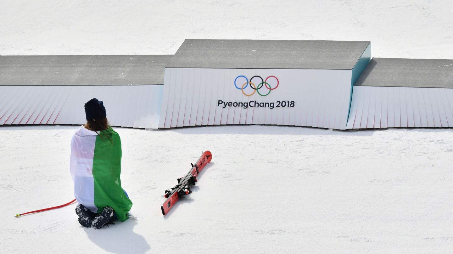 Pyeongchang 2018: Im stiller Dankbarkeit: Die italienische Skirennläuferin Sofia Goggia kniet nach der Flowerzeremonie vor dem Podium, auf dem sie ganz oben gestanden hat. Goggia gewann Gold in der Abfahrt, nachdem sie zahlreiche Verletzungen und Rückschläge in ihrer Karriere verkraften musste. Im stiller Dankbarkeit: Die italienische Skirennläuferin Sofia Goggia kniet nach der Flowerzeremonie vor dem Podium, auf dem sie ganz oben gestanden hat. Goggia gewann Gold in der Abfahrt, nachdem sie zahlreiche Verletzungen und Rückschläge in ihrer Karriere verkraften musste.