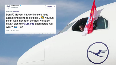 Ein Pilot hält eine Bayern-Flagge aus einem Lufthansa-Flugzeug