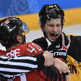 An die Gurgel: Die Kanadier sind mächtig in Rage, als sie gegen die Deutschen im Eishockey-Halbfinale auf die Verliererstraße geraten. Maxim Lapierre (l.) greift dem Deutschen Frank Mauer sogar an die Gurgel.