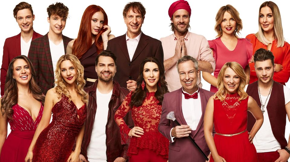 Die prominenten Kandidaten von "Let's Dance" bei RTL stehen in Rottönen gekleidet auf einem Gruppenbild zusammen