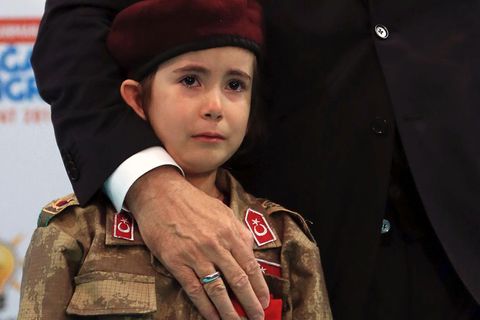 Der türkische Präsident Recep Tayyip Erdogan mit einem weinenden Mädchen in Militäruniform