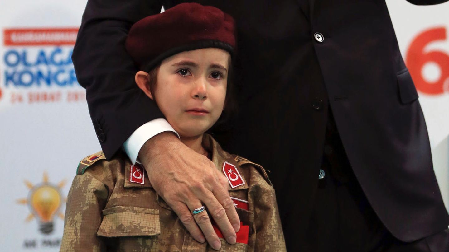 Der türkische Präsident Recep Tayyip Erdogan mit einem weinenden Mädchen in Militäruniform