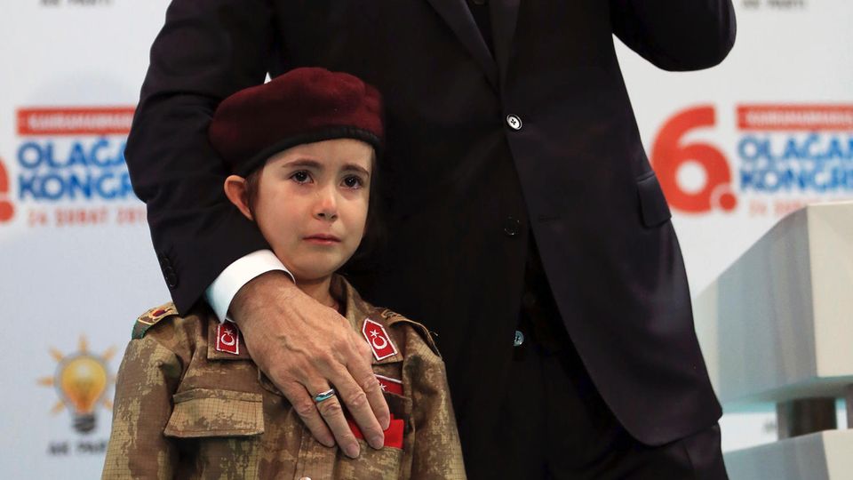 Recep Tayyip Erdogan steht neben einem weinenden Mädchen in Soldatenuniform