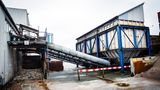 Auf Förderbändern wandert das Altglas in die Anlage. Große Magneten ziehen die Eisendeckel aus den Scherben, die Deckel landen in einem eigens abgetrennten Bereich. (links)