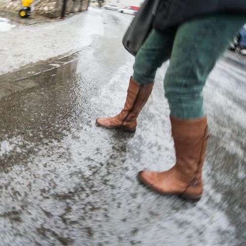 Eine Frau geht bei Glatteis über eine Straße